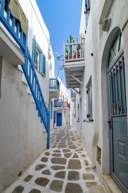 Geleneksel dar kaldırımlı sokaklar, Yunan adasının güzel sokakları. Beyazlatılmış evler, saksılar, mavi balkonlar, merdivenler. Mykonos, Yunanistan