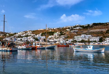 Yunan ada limanında güzel bir yaz günü. Balıkçı tekneleri, iskeleye demirlenmiş yatlar. Ön planda küçük bir balıkçı teknesi. Mykonos, Cyclades, Yunanistan.