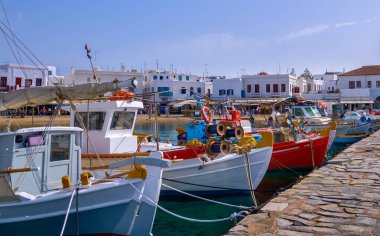 Güzel bir yaz günü, Yunan adasının marinası. İskeleye demirlemiş balıkçı tekneleri. Mykonos, Cyclades, Yunanistan. Beyazlatılmış evler. Akdeniz yaşam tarzı. 