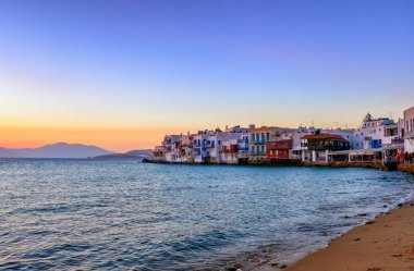 Küçük Venedik 'in güzel gün batımı manzarası, Mykonos, Yunanistan. Deniz dalgalarının üzerindeki eski balıkçı evlerinde barları, kafeleri, restoranları olan romantik bir mahalle.