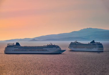 Limanda iki büyük turist yolcu gemisi manevrası. Güzel gün batımı gökyüzü. Altın saat için renkli bir atış. Deniz yolculuğu, macera, romantik balayı.
