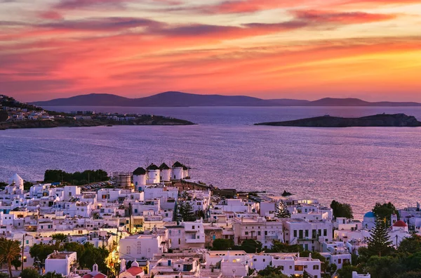 Prachtige zonsondergang uitzicht op beroemde traditionele witte molens op heuveltop, Mykonos, Griekenland. Whitewashed huis, kleurrijke zonsondergang hemel, zomer, stad licht op — Stockfoto