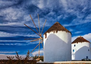 Yunanistan 'ın ünlü Mykonos turistik merkezi. İki geleneksel beyazlatılmış yel değirmeni. Yaz, mavi gökyüzü, güzel bulutlar. Seyahat hedefi