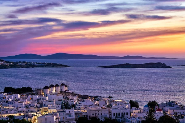 Coucher de soleil coloré sur les célèbres moulins à vent blancs traditionnels, Mykonos, Grèce. Maisons blanchies à la chaux, ciel coloré au coucher du soleil, destination estivale, lumières de la ville allumées — Photo