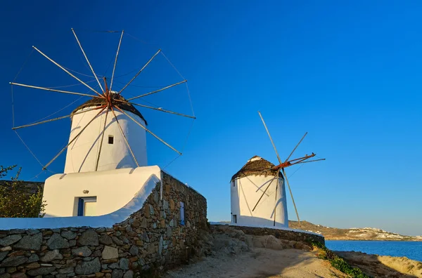 Słynna atrakcja turystyczna, Mykonos, Grecja. Dwa tradycyjne bielone wiatraki. Lato, rano, czyste błękitne niebo, cel podróży, kultowy widok. — Zdjęcie stockowe