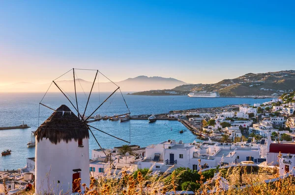 Belle vue sur le moulin à vent blanc grec surplombant Mykonos, Grèce au coucher du soleil. Baie, bateaux, paquebots de croisière, maisons blanchies à la chaux, îles, arrière-plan flou. — Photo
