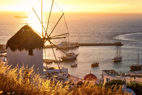 Gouden zonsondergang boven de zeespiegel in Mykonos, Griekenland. Beroemde traditionele witte windmolen op hete zomeravond in het zonlicht. Romantische reisbestemmingen — Stockfoto