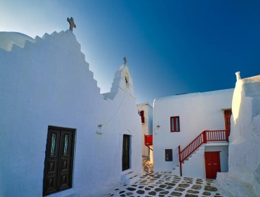 Yunanistan 'ın Mykonos Adası' ndaki ünlü turizm merkezi. Beyaz Rum Ortodoks Kilisesi Panagia Paraportiani 'ye giriş. Beyazlatılmış duvarlar, derin mavi gökyüzü