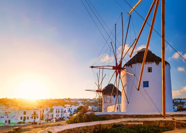 Famous tourist attraction of Mykonos, Greece. Traditional whitewashed windmills in row against sun. Summer, sunrise, travel destination, iconic view. — Zdjęcie stockowe