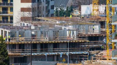 İnşaat alanındaki ekip çalışmasının 4K kısa zamanlı görüntüsü. Modern apartman dairesi, konut binası, beton dökme teknolojisi, çelik ağ, gündüz vakti, 
