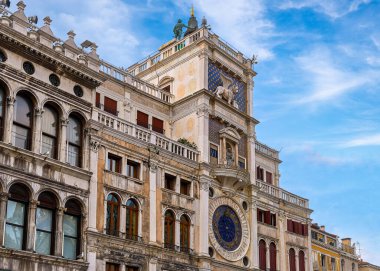 Venedik, İtalya 'daki St. Marks Meydanı' ndaki ünlü Torre dellOrologio veya Saat Kulesi. Moors, Lion, Virgin Mary heykelleri, ortaçağ saati, mavi gökyüzü, bulutlar.