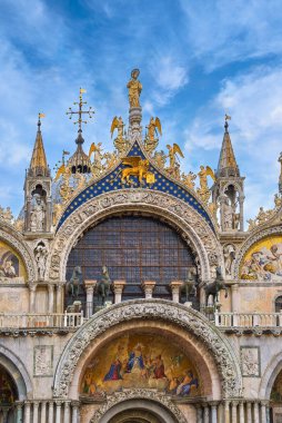 Ayrıntılar. Venedik 'teki St. Mark Katedrali' nin ana girişi. İtalya. UNESCO Dünya Mirası şehri, heykeller, mozaikler, oymalar, mavi gökyüzü ve bulutlar. Dikey çekim