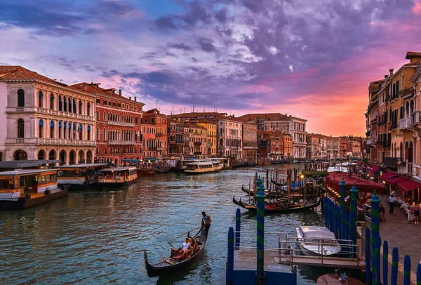 Sunset view of Grand Canal, Venice, Italy. Vaporetto or waterbus station, boats, gondolas moored by walkways, beautiful sunset clouds, UNESCO heritage — Stock Photo, Image