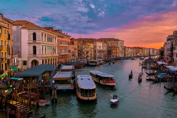Sunset view of Grand Canal, Venice, Italy. Vaporetto or waterbus station, boats, gondolas moored by walkways, beautiful sunset clouds, UNESCO heritage — Stock Photo, Image