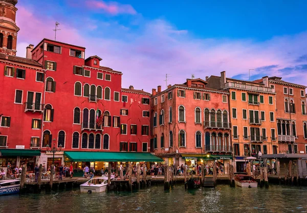 Vista do pôr-do-sol de edifícios à beira-mar de Veneza, Itália. Barcos atracados por passarelas, belas nuvens de pôr do sol, património da UNESCO, noite, turistas caminhando — Fotografia de Stock