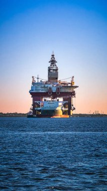 Lizbon, Portekiz - 17 Aralık 2023: Boskalis MV Blue Marlin, yarı-batırılabilir ağır yük gemisi, devasa petrol platformu taşıma, deniz lojistik mühendisliği, küresel enerji sektörü için etkileyici mühendislik. Gemi, renkli günbatımında açık sularda kargo