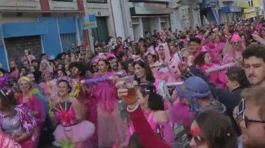 10 Şubat 2024 - Lizbon, Portekiz: Kalabalık Colombina Clandestina geçit töreniyle karnavalı kutlamak için şehir sokaklarında toplandı. Katılımcılar parlak pembe kostümler giyer, perküsyon enstrümanları çalar ve canlı müzik çalar, birlikte hareket ederken dans ederler..