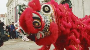 9 Şubat 2024 - Lizbon, Portekiz: Güneşli bir günde düzenlenen Ay Yeni Yılı kutlamaları sırasında Avrupa açıkhava meydanında dans ettikten sonra geleneksel Çin Kırmızı ve Beyaz Aslanları ile fotoğraf çektirmek için poz veren seyirci. Aslan dansı şans, servet ve refah getirir.