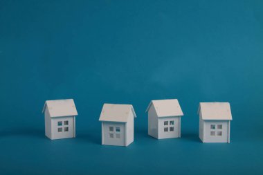 Mavi arka plana karşı dört beyaz ev. Hygge görüntüsü. Resim kopyalama alanı içeriyor