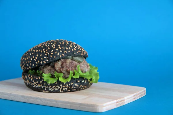 Hamburger Meja Pemotongan Kayu Terisolasi Dengan Latar Belakang Biru Gambar — Stok Foto