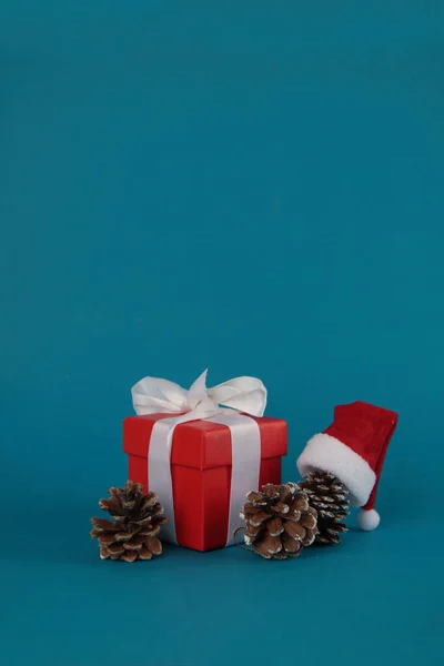 Geschenkdoos Dennenappels Kerstbal Kerstmuts Geïsoleerd Blauwe Achtergrond Kerstconcept Afbeelding Bevat — Stockfoto