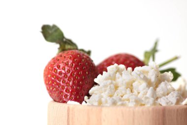 Beyaz arka planda izole edilmiş, ahşap bir peynir kasesindeki çilekler. Sağlıklı beslenme konsepti. Resim kopyalama alanı içeriyor