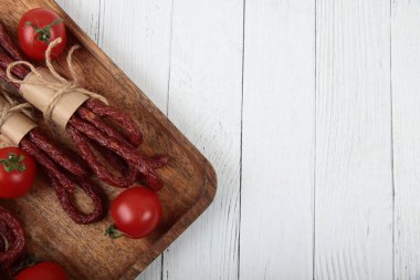 Kabanos ya da kababanossi - beyaz ahşap zemin üzerinde sığır eti ve ottan yapılmış geleneksel Polonya kuru füme sosisi. Resim kopyalama alanı içeriyor