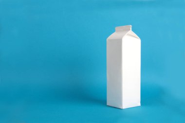 Mavi arka planda beyaz karton paket var. Resim kopyalama alanı içeriyor