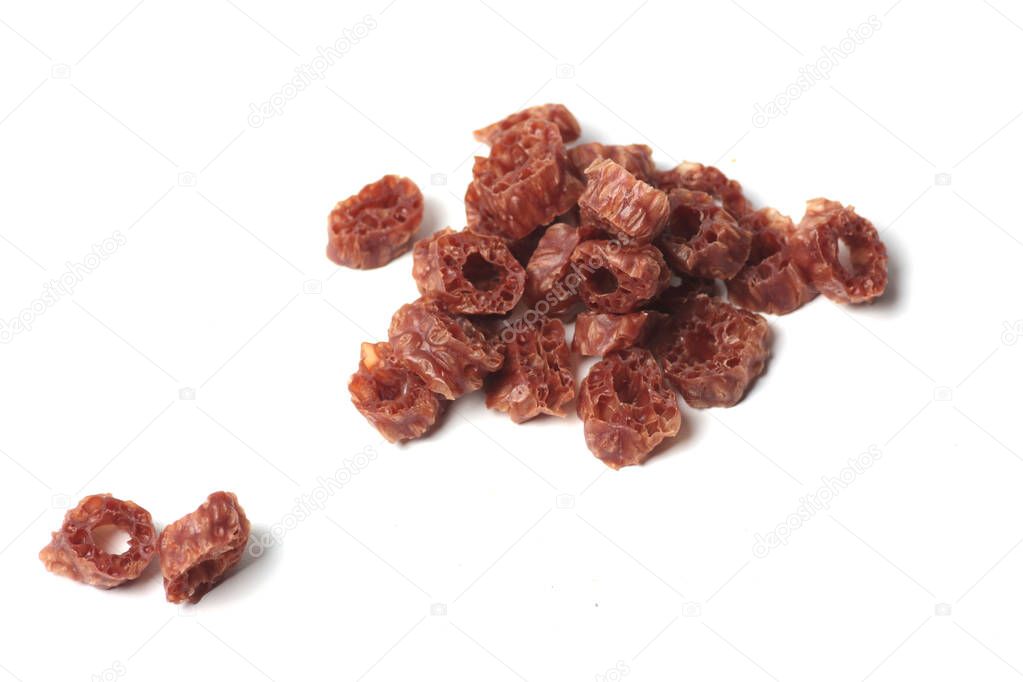 pets food concept - a pile of dried meat rings for dogs isolated on white background flat lay. Image contains copy space