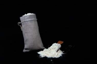 Fırın kavramı - siyah arka planda izole edilmiş bir torba ve un. Resim kopyalama alanı içeriyor