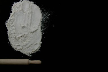 Koyu bir zemin üzerinde merdane ve beyaz un vardı. Metin için boş alan. Yemek pişirme konsepti