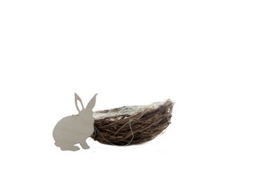 Paskalya yumurtası avı kavramı. Tavşan ve beyaz arka planda bir yuva. Resim kopyalama alanı içeriyor
