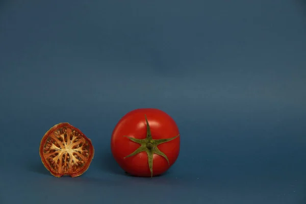 Frische Tomaten Und Getrocknete Tomaten Isoliert Auf Blauem Hintergrund Konzept — Stockfoto