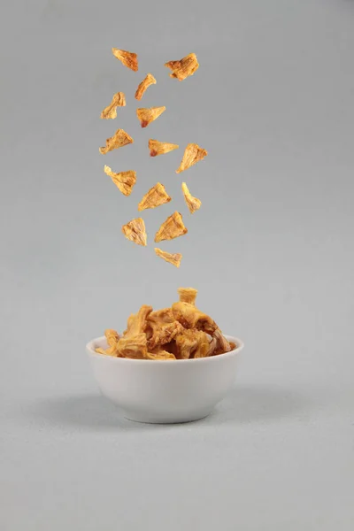 Vliegend Voedsel Concept Gedroogde Ananas Gieten Een Kom Tegen Grijze — Stockfoto