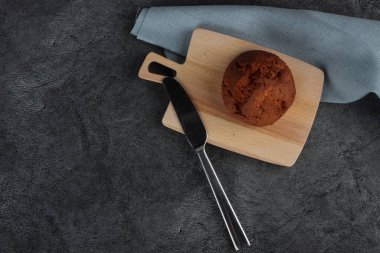 Kesme tahtasındaki çörek ve arka plandaki gri düz zemine karşı peçete. Resim kopyalama alanı içeriyor