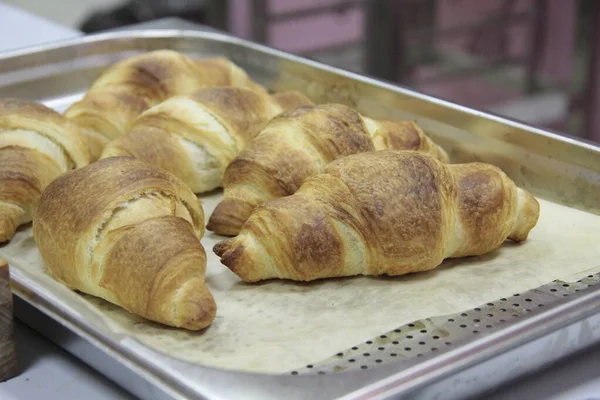 six fresh croissants on a dripping-pan cooking concept
