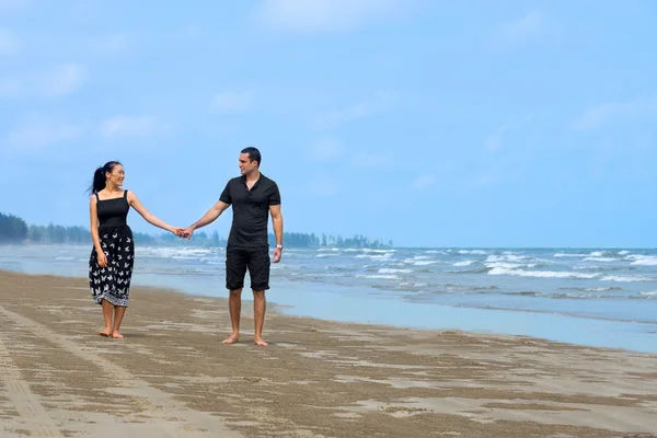 Feliz pareja interracial caminando en la playa — Foto de Stock