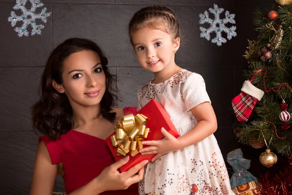 Mulher feliz e menina pequena com presente de Natal — Fotografia de Stock