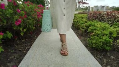 Özgürlük, barış, insanlar konsepti - neşeli çekici Asyalı kız günlük giysiler içinde bahçede çiçeklerle yürüyor