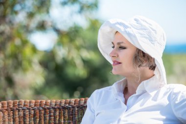 Bahçede bir bankta oturan kadın