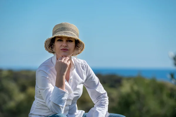 Woman  in hat siiting in nature — Stock Photo, Image