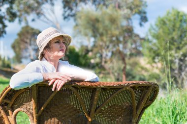 Bahçede bir bankta oturan kadın