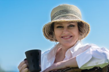 Bahçedeki kahve ile oturan kadın