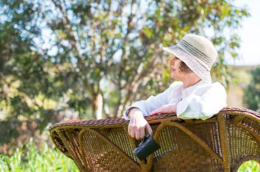 Bahçede bir bankta oturan kadın