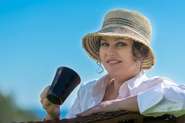 Woman  sitting  in the garden with cup of coffee — Stock Photo, Image