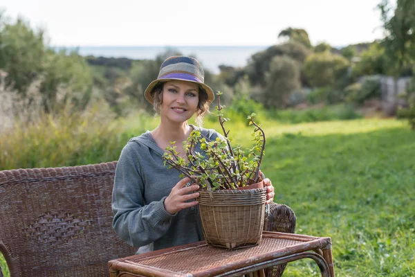 Woman sitting in nature with  plant — Stock Photo, Image