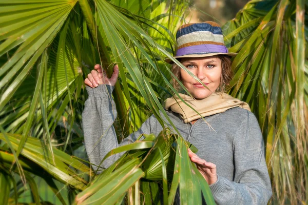 Woman with headscarf next to palms — Stock Photo, Image