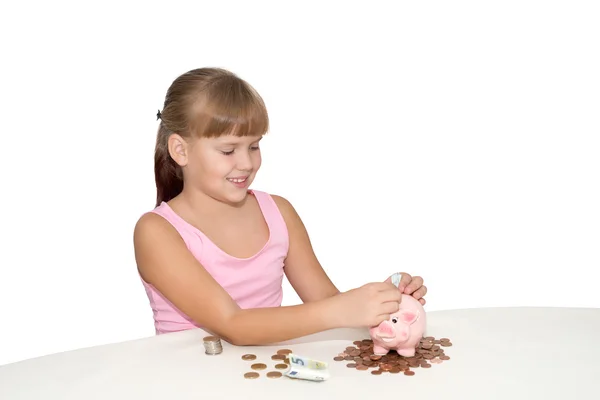 Linda niña poniendo dinero en alcancía aislado — Foto de Stock