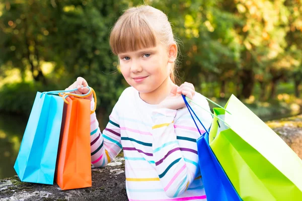 Little  girl  after shopping in the park — Stock Photo, Image