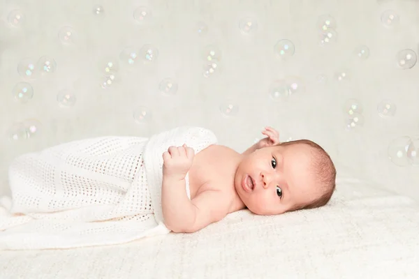 Laying newborn baby with bubbles — Stock Photo, Image